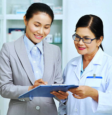 two woman looking at the paper